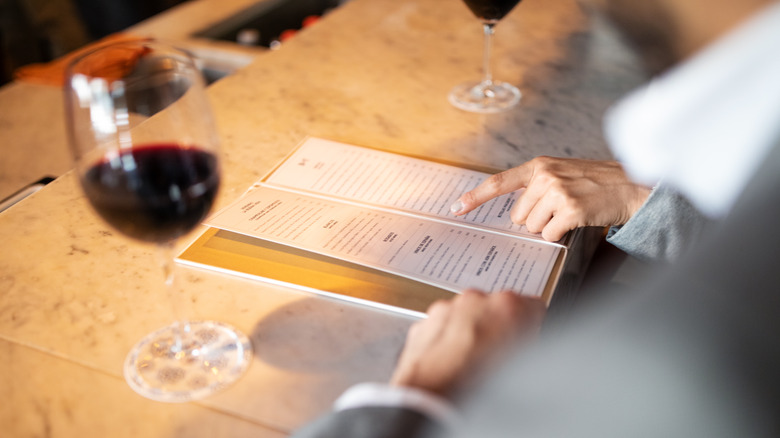 person pointing at menu at restaurant