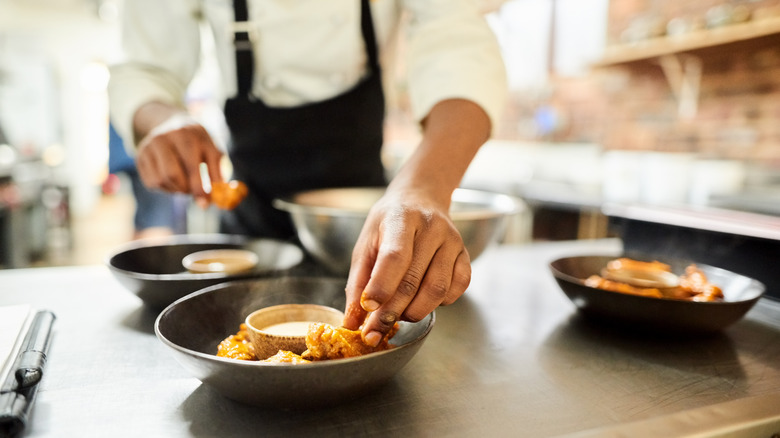 cook arranging food on plate