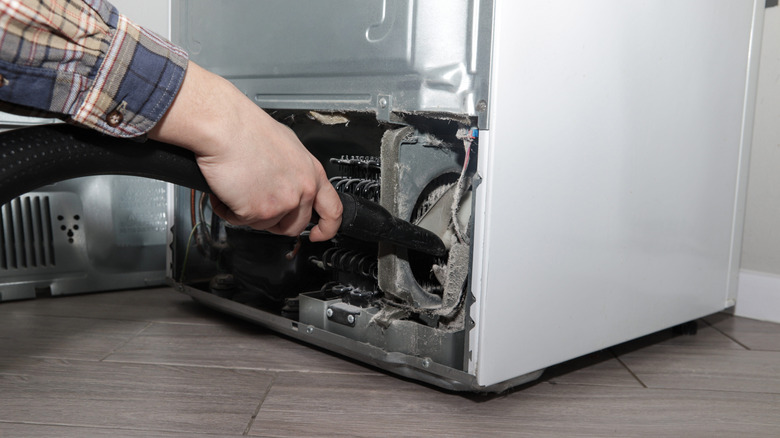 Vacuuming a refrigerator condenser