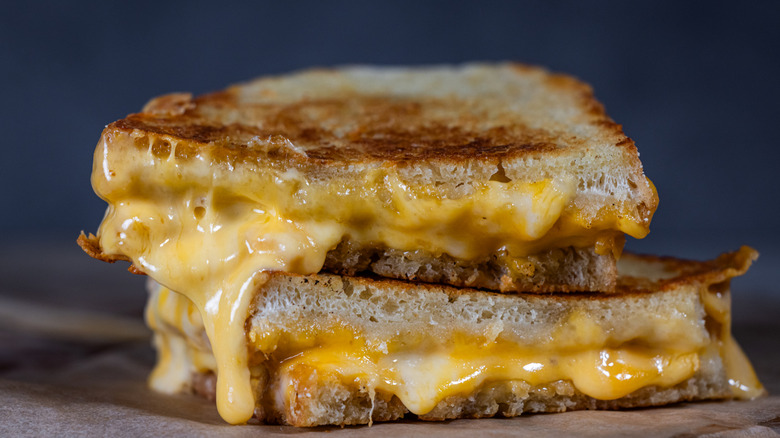 A close-up of a grilled cheese sandwich with the cheese melting out