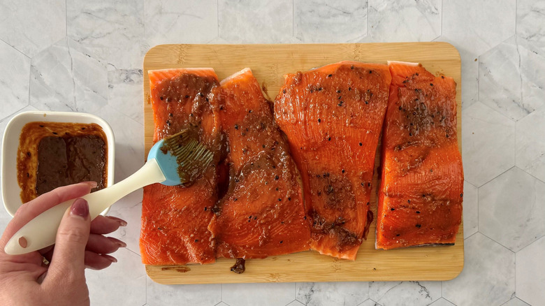 Pastry brush brushing glaze onto salmon