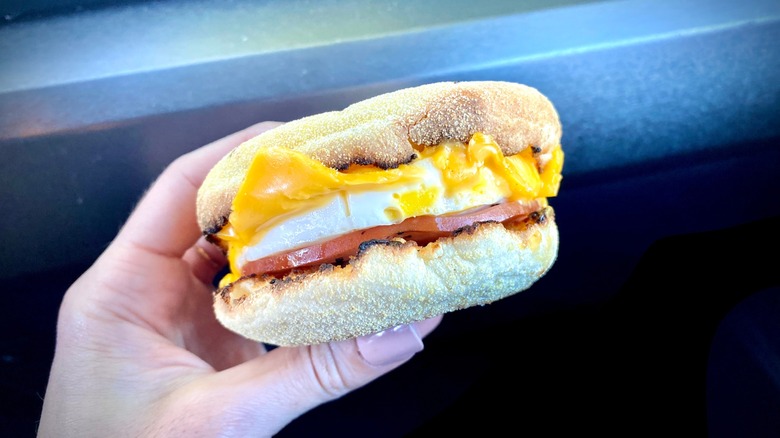 hand holds a mcdonald's mcmuffin sandwich