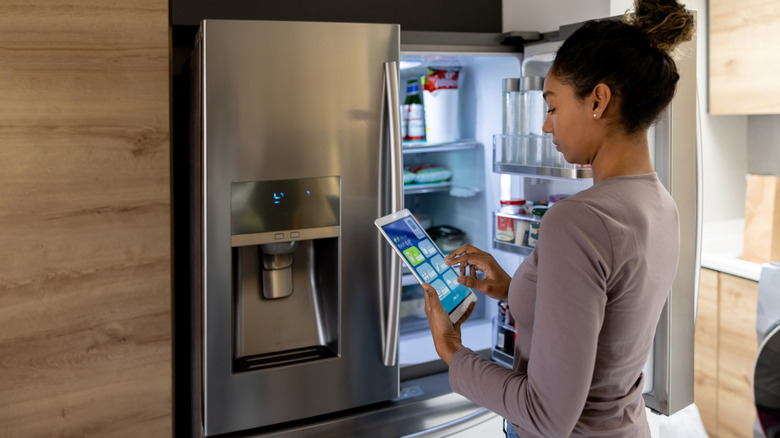 Woman controlling her fridge with tablet