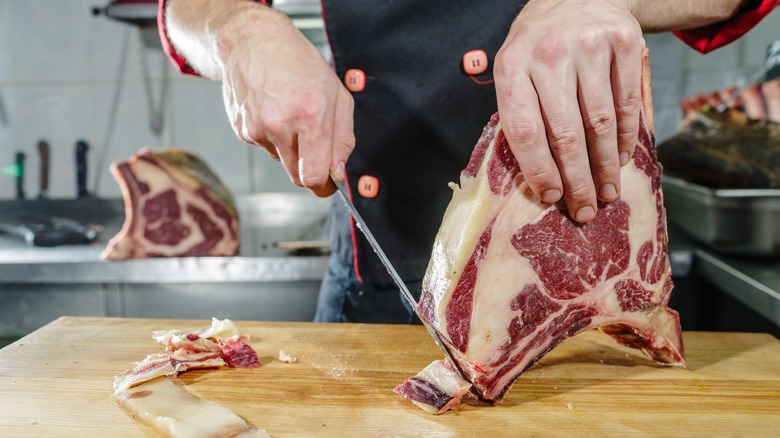 trimming cut of beef with knife