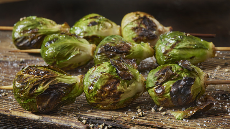 Grilled Brussels sprouts on a skewer on wood table