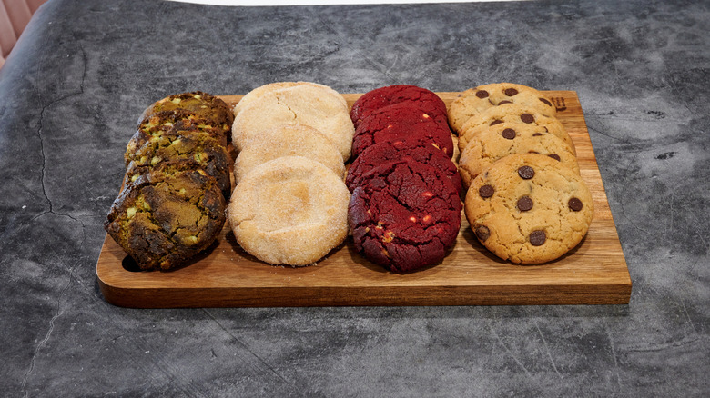Four different types of cookies on a wooden tray