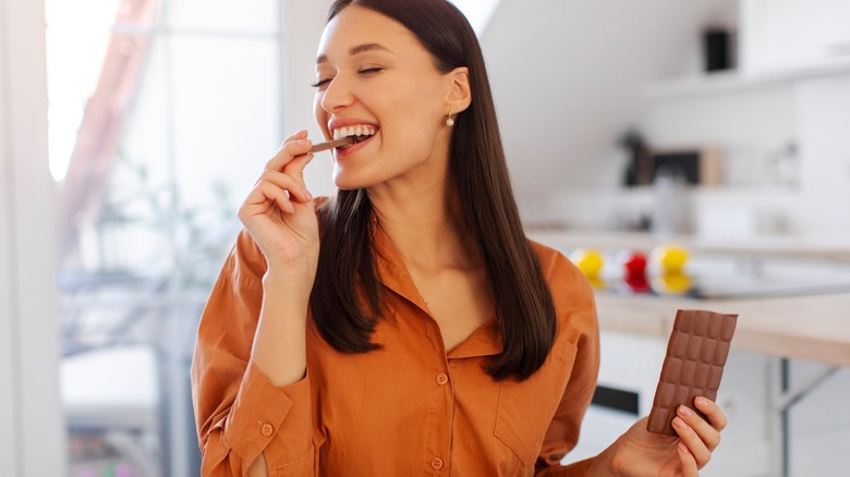 woman enoys a chocolate candy bar