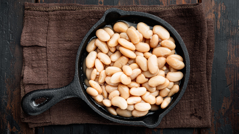 Canned white beans in a cast iron pan