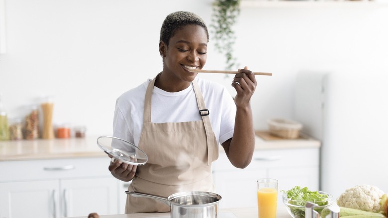 happy home cook savors food from a pan