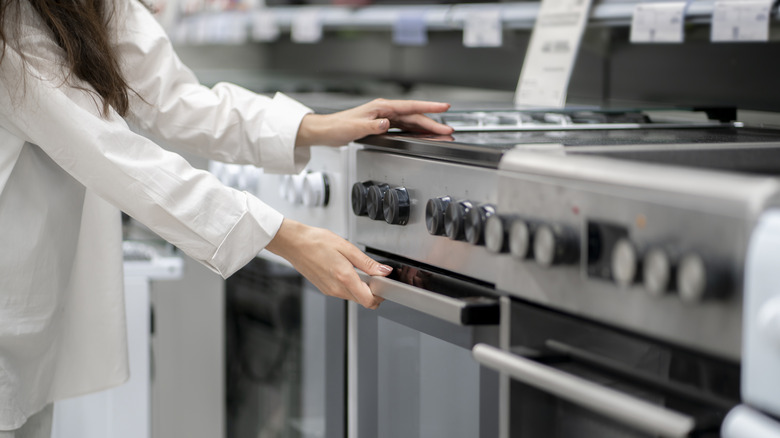 Someone browsing ovens at an appliance store