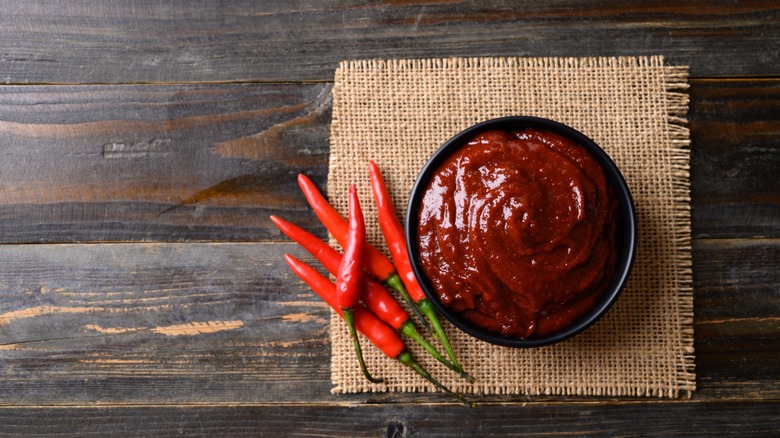 gochujang in bowl with chili peppers