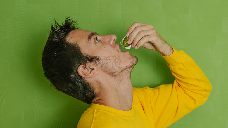 Man drinking an olive oil shot