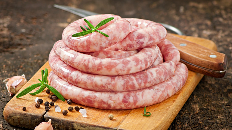 A coil of fresh sausage on a wooden board