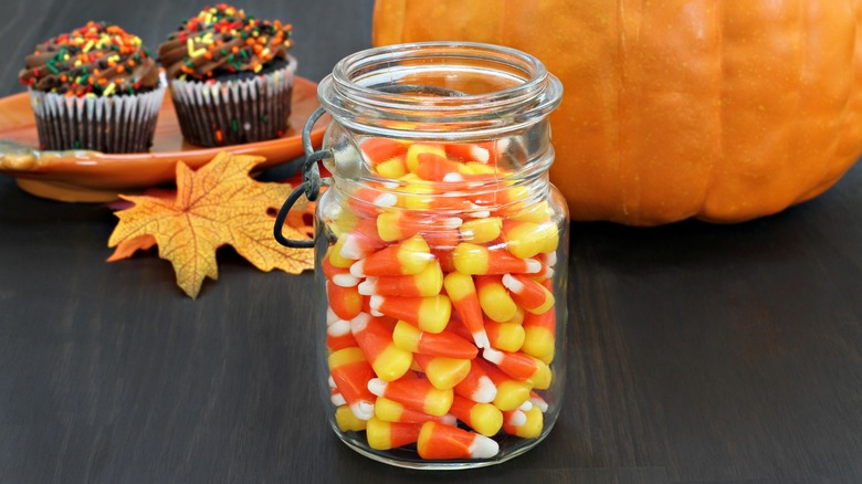 mason jar with candy corn and autumn decor