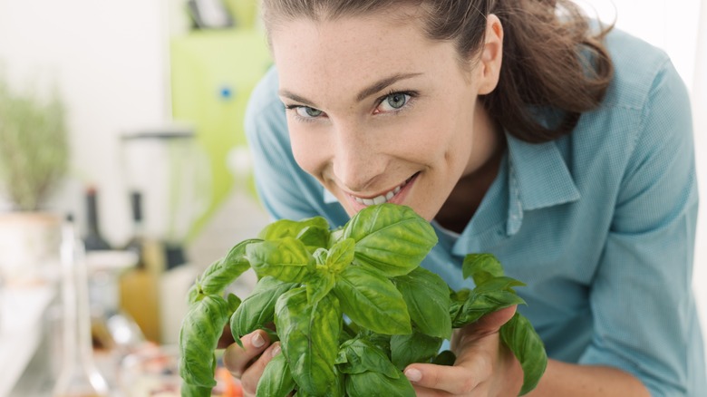 smiling woman with healthy basil plant