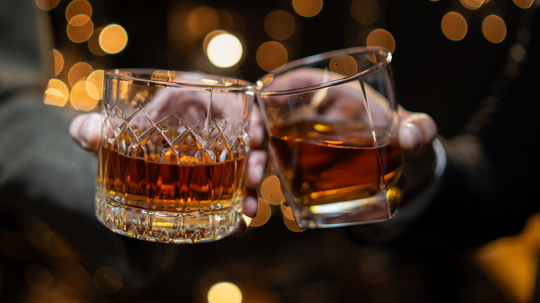 Two classes of whiskey being clinked
