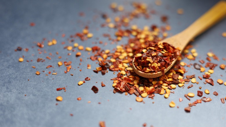 red pepper flakes on wooden spoon