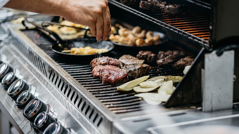 seasoning food on a large grill