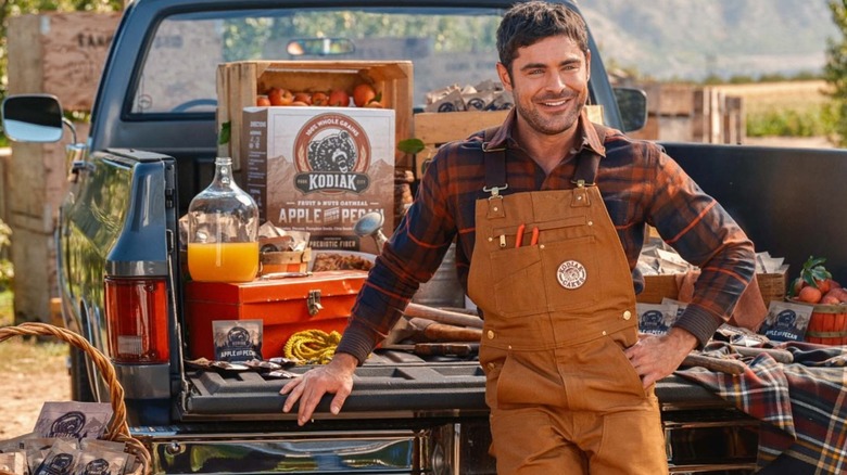 zac efron posing for kodiak cakes with truck