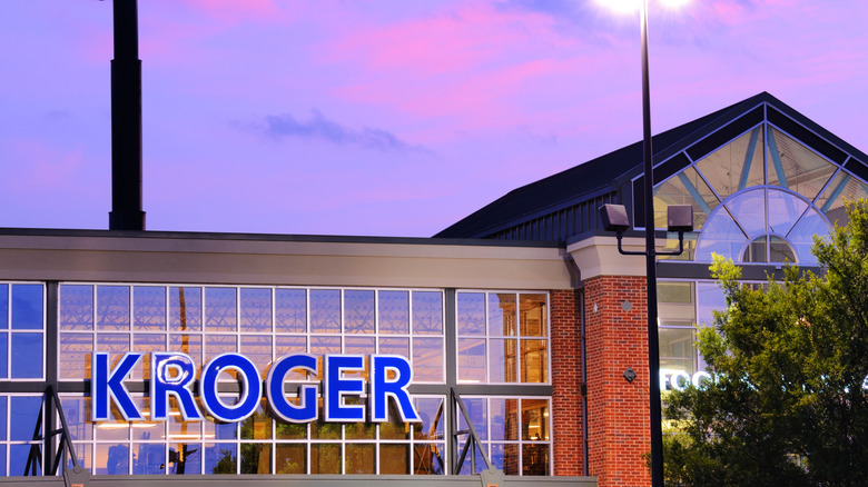 Illuminated Kroger sign at dusk.