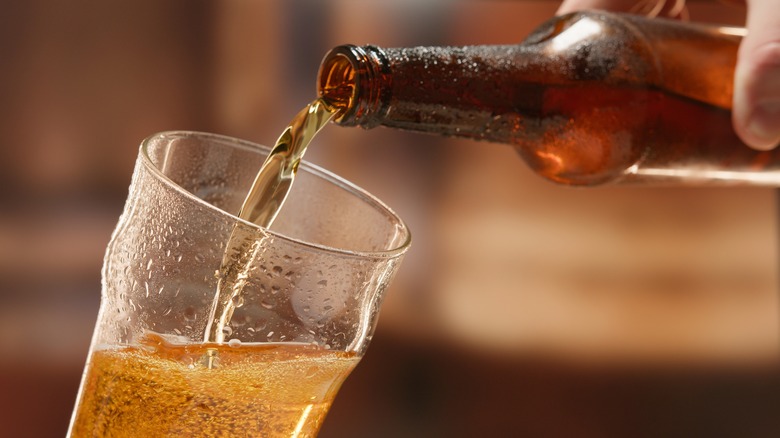 Bottled beer pouring into pint glass