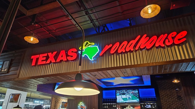 interior of texas roadhouse restaurant with neon sign