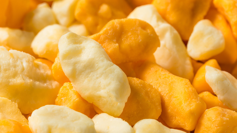 Closeup of yellow and white cheese curds.