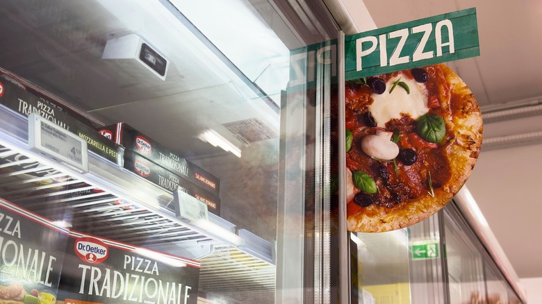 Sign reading "Pizza" in frozen aisle of grocery store