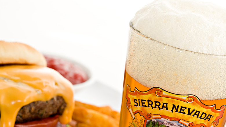 Sierra Nevada pale ale next to a cheeseburger and fries