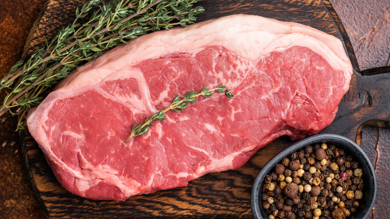 Raw New York strip beef steak on a cutting board