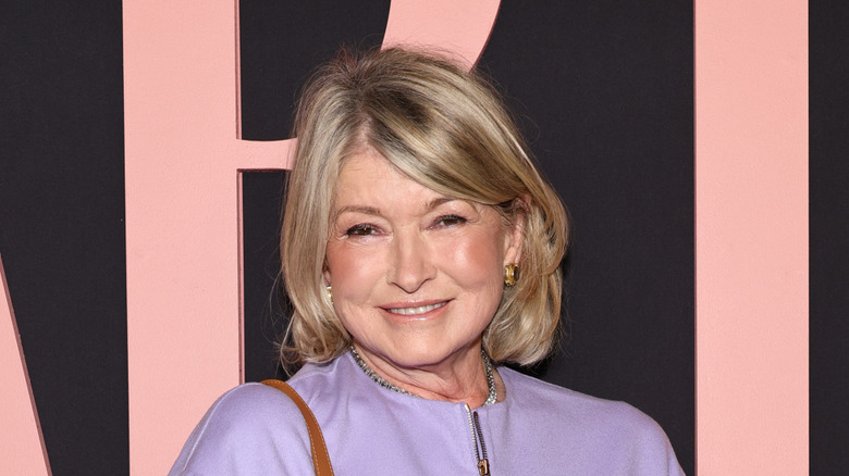 Martha Stewart smiling at red carpet event, wearing purple sweater.