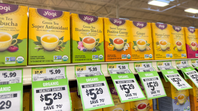 Boxes of Yogi Tea in various flavors on two rows of grocery store shelves