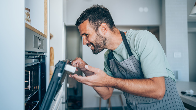 man opening oven door