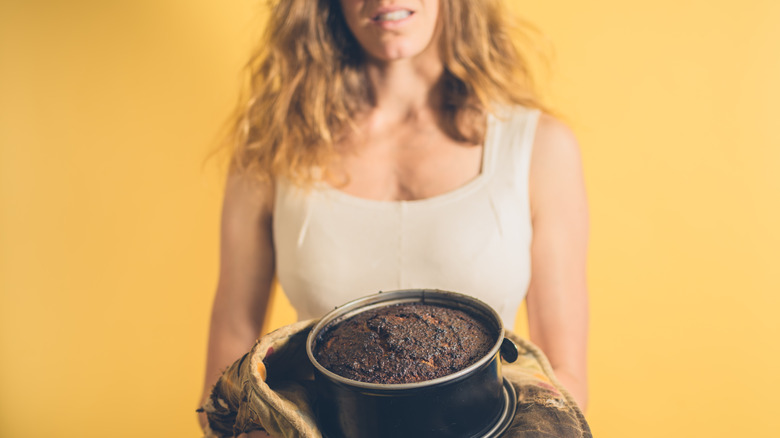 woman holding burnt cake