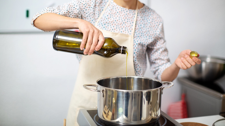 woman pouring oil into pot