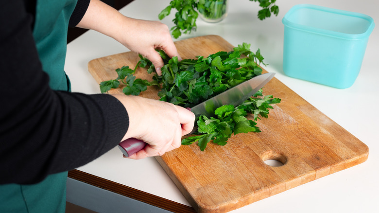 A person chopping fresh parsley
