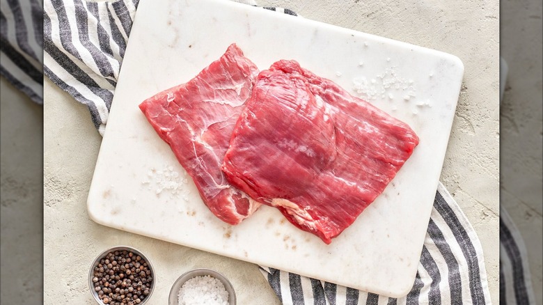 Moink flank steak rests on a cutting board