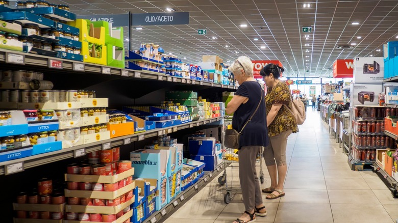 two women shop canned and bottled goods at aldi