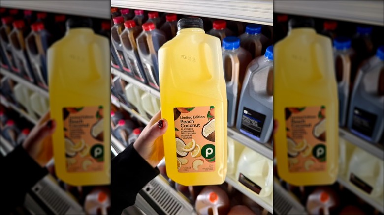 hand holds a half gallon of flavored lemonade