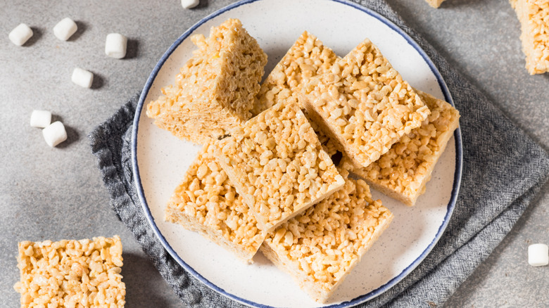 rice krispies treats cut into squares on white plate.