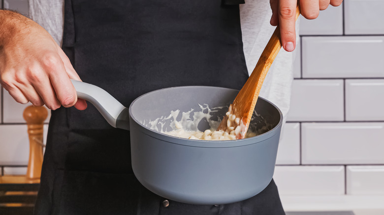Person stirring food in saucepan