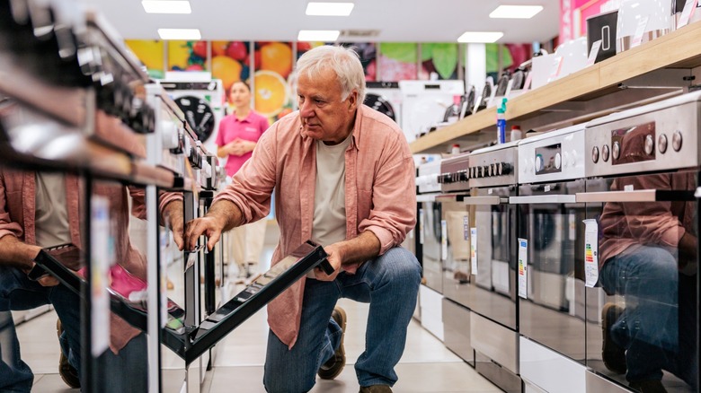 an older man looks at stoves for sale