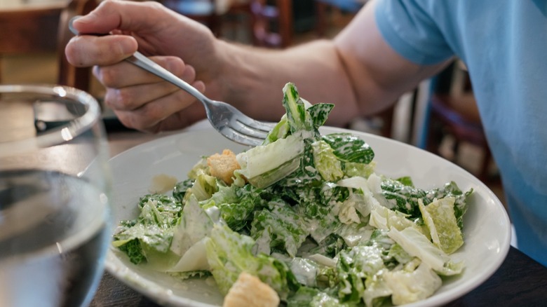 eating a caesar salad with fork