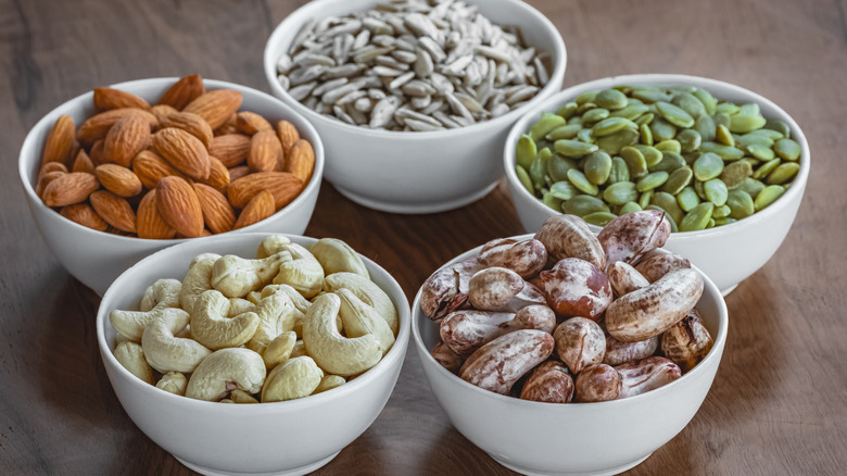 Assorted nuts and seeds in while bowls