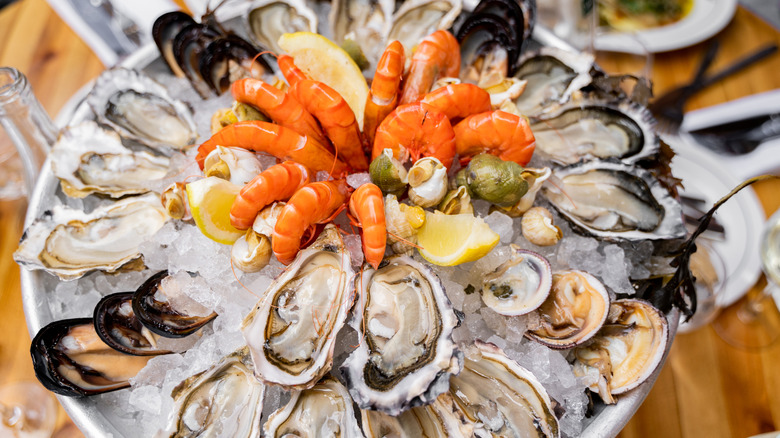 A chilled platter of oysters, shrimp, mussels, and lemon slices