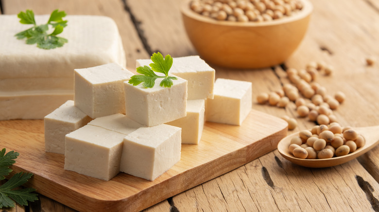 Cubes of hard tofu and soybeans on a wooden surface