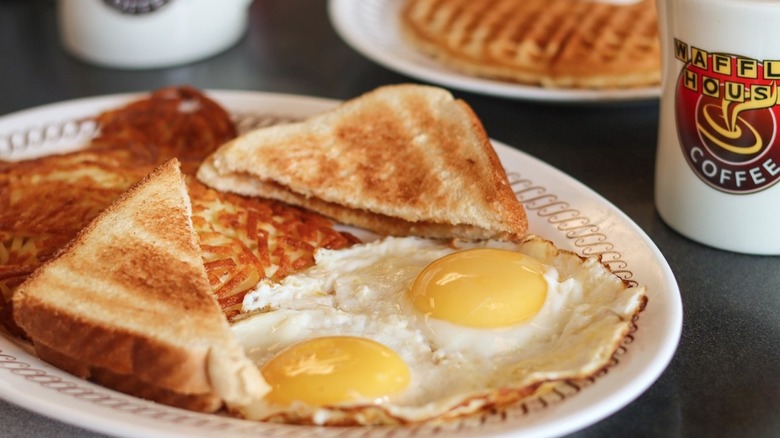 Waffle House breakfast on table, including eggs and waffles.