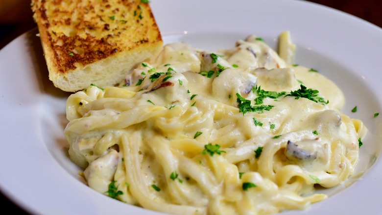 plate of alfredo pasta with bread