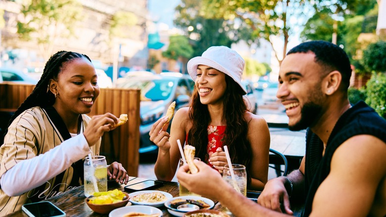 friends eat a meal around a table