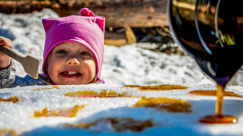 A child eating maple syrup snow candy